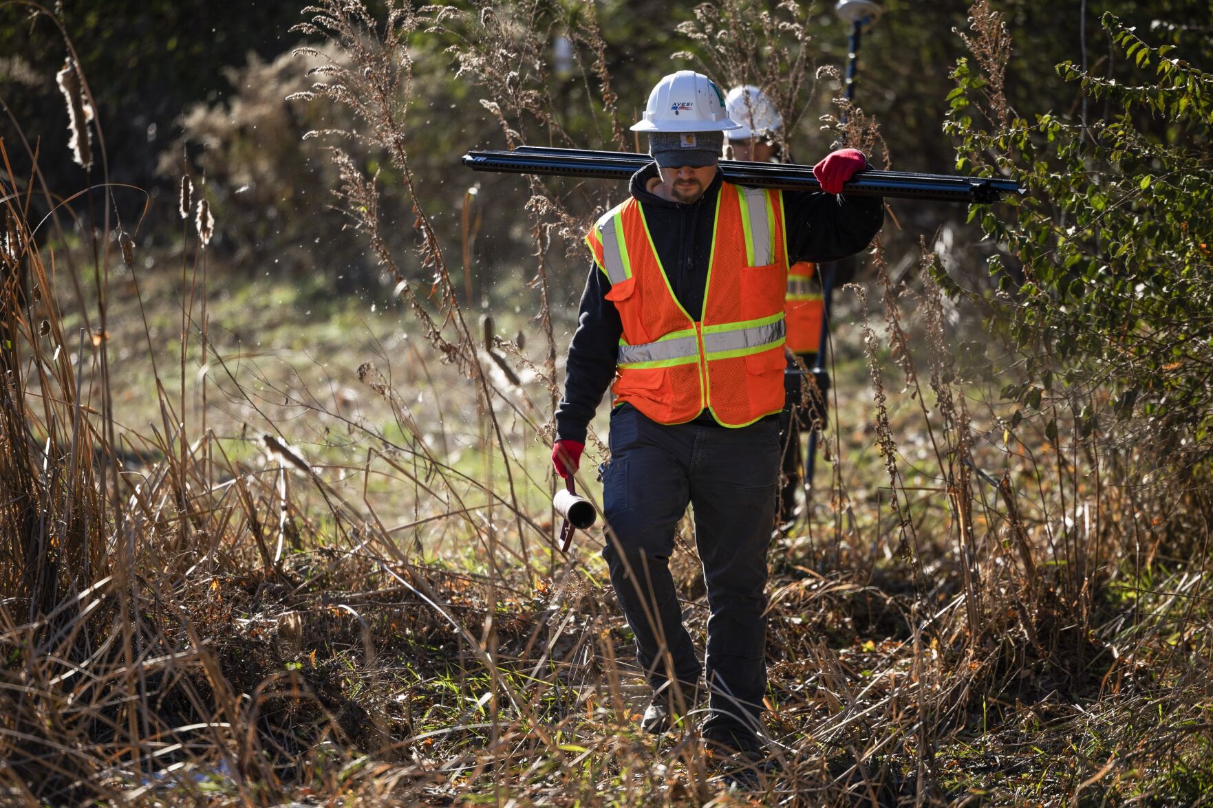 Contractors with the Army Corps of Engineers install signage along Coldwater Creek